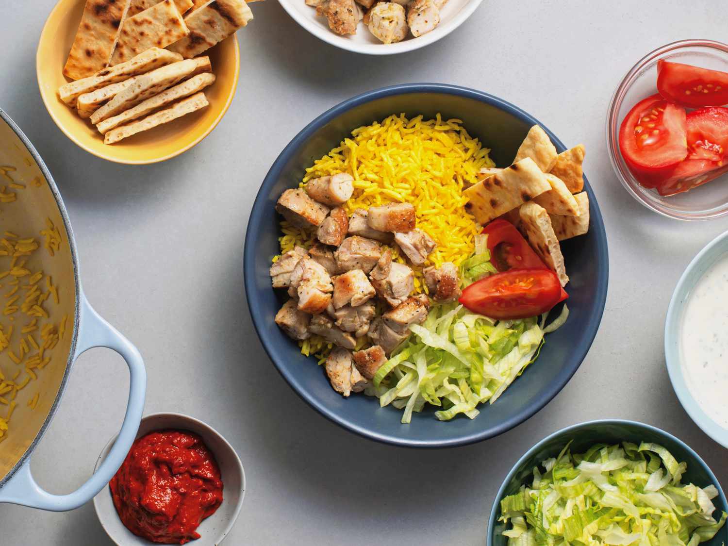 a scene showing the assembly of a Halal cart-style chicken and rice bowl