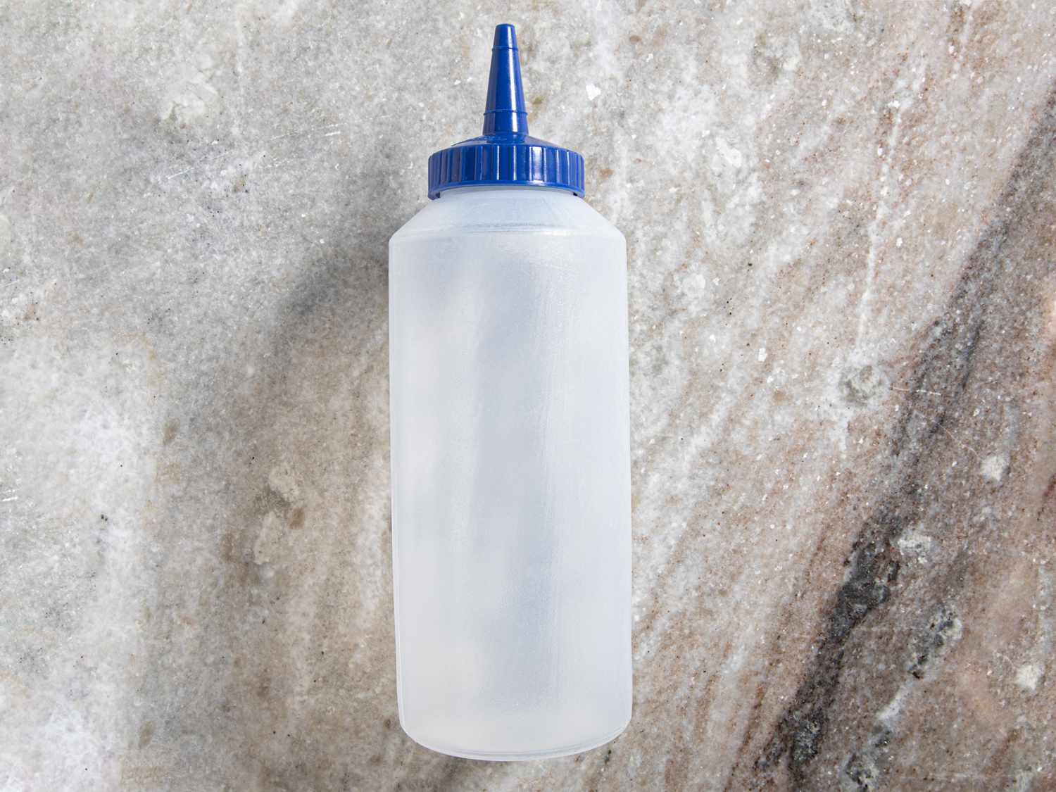 Vollrath squeeze bottle on a grey marble countertop
