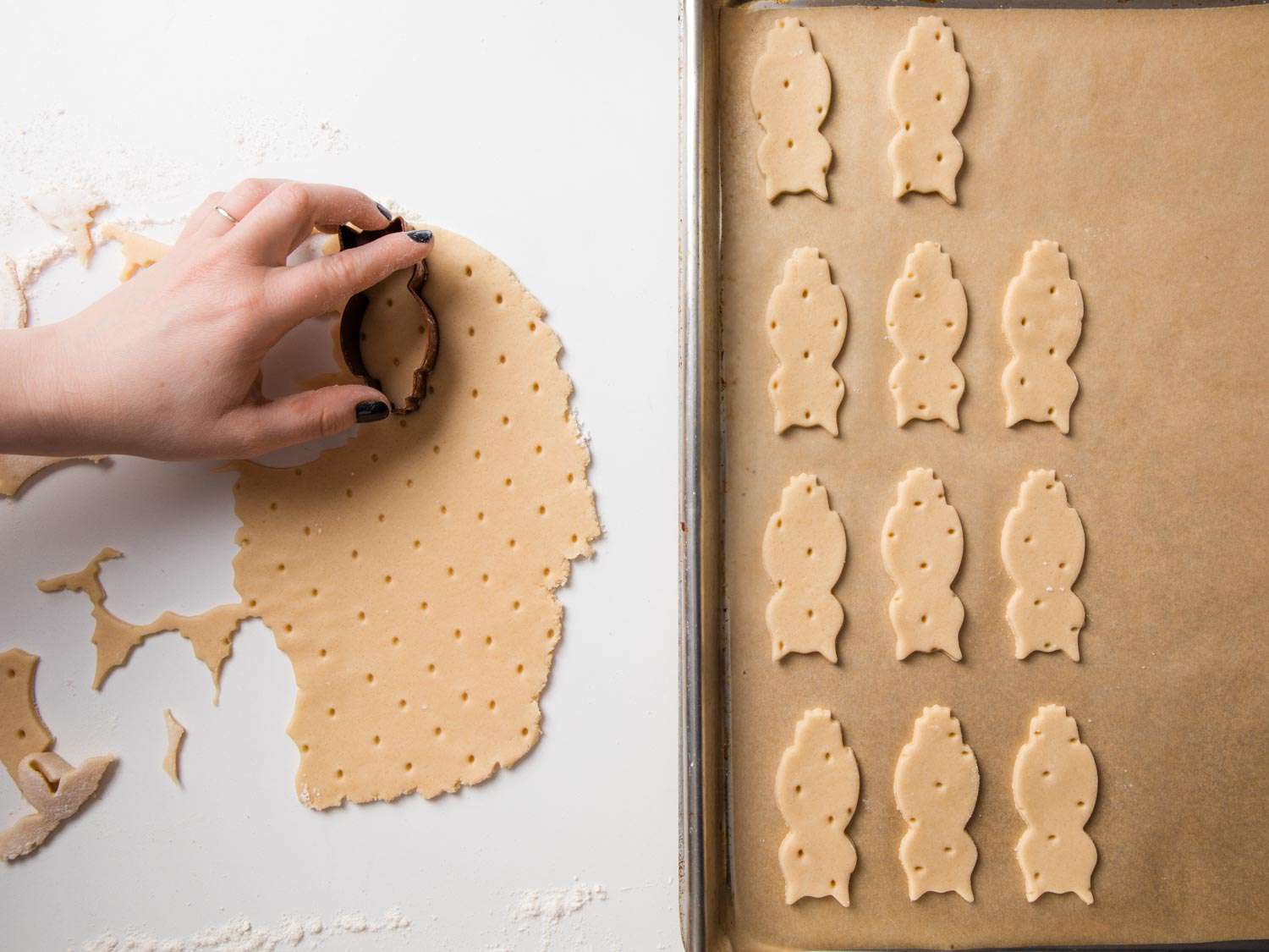 Overhead shot of hand cutting out shortbread cookies from rolled dough with more cookies on baking sheet.
