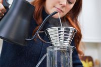 Person pouring water from a kettle into a Kalita Wave 185 Dripper