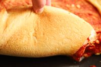 Checking bottom of the pizza after being cooking in the Emile Henry Deep Dish Pizza Pan 