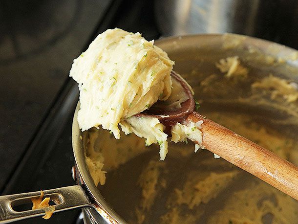 A spoonful of pate a choux paste, mounded on a wooden spoon.