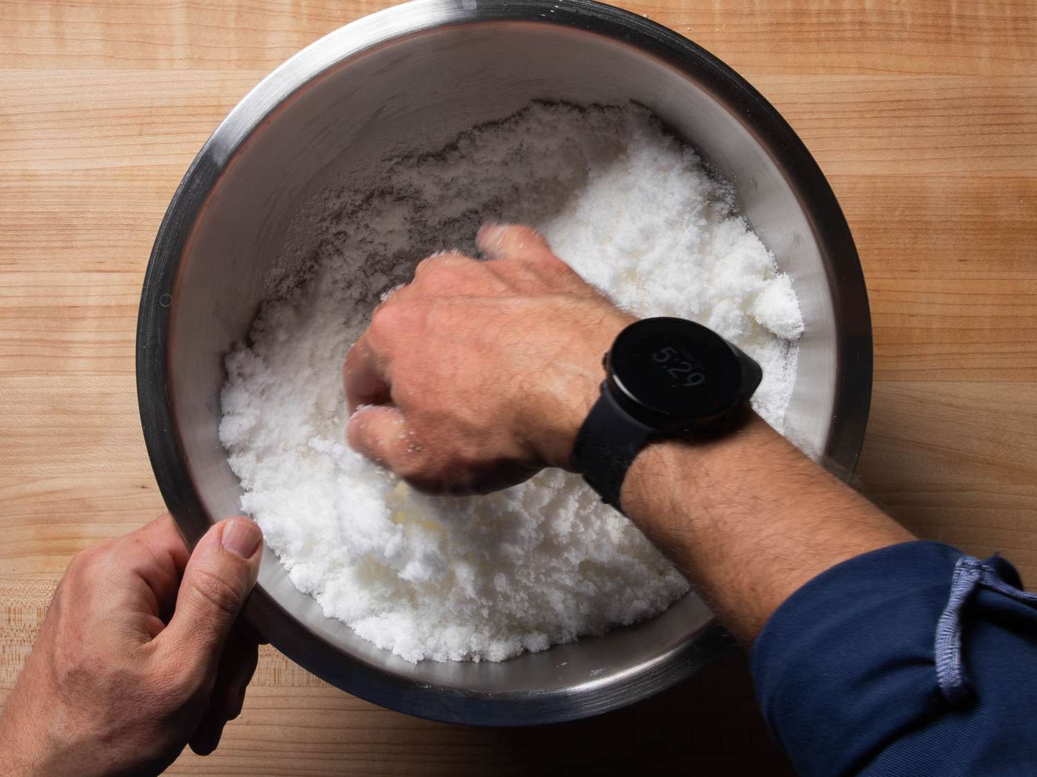 Mixing water into kosher salt for a salt-baked fish.