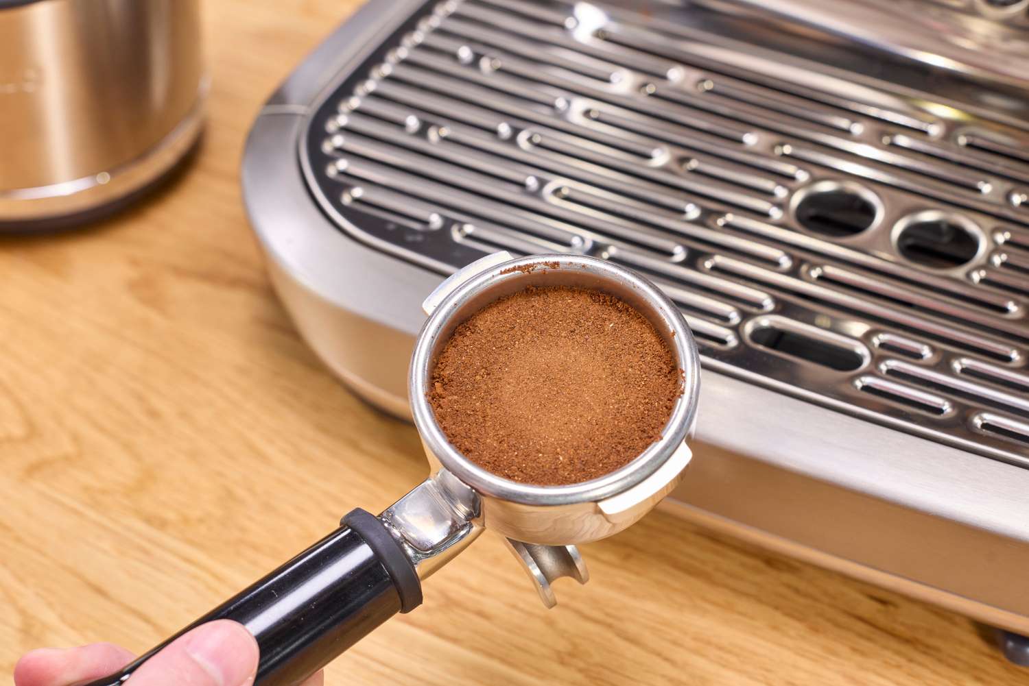 The portafilter is added to the Breville The Oracle Dual Boiler Espresso Machine before making espresso