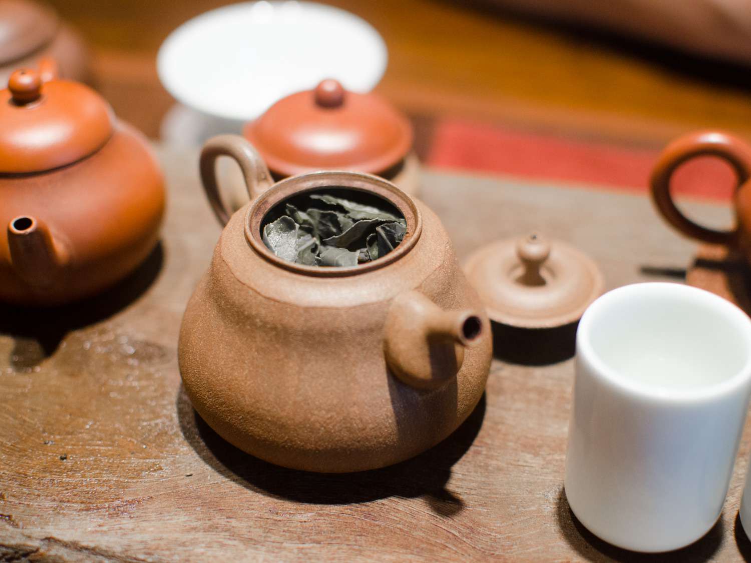 A brown ceramic teapot filled with oolong tea leaves