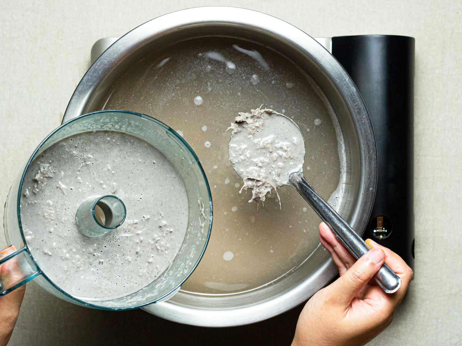 Overhead view of spooning processed fish into broth
