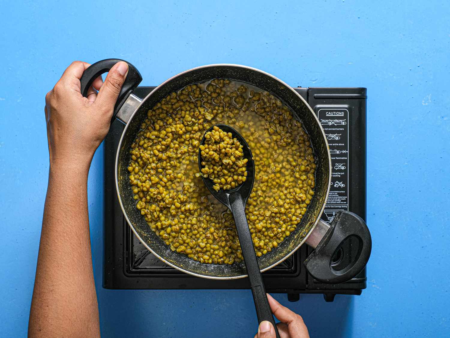 Beans mixed and cooked about 30 minutes in a dutch oven, on a blue surface 