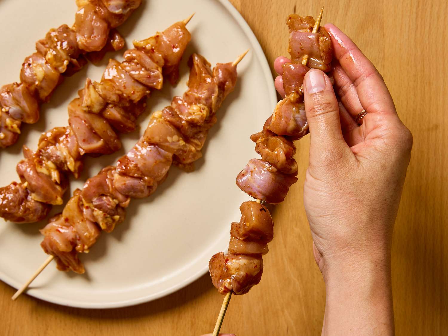 Chicken pieces on skewers being prepared