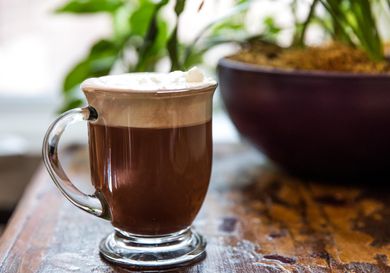 glass mug of Milanese hot chocolate and coffee layered with whipped cream
