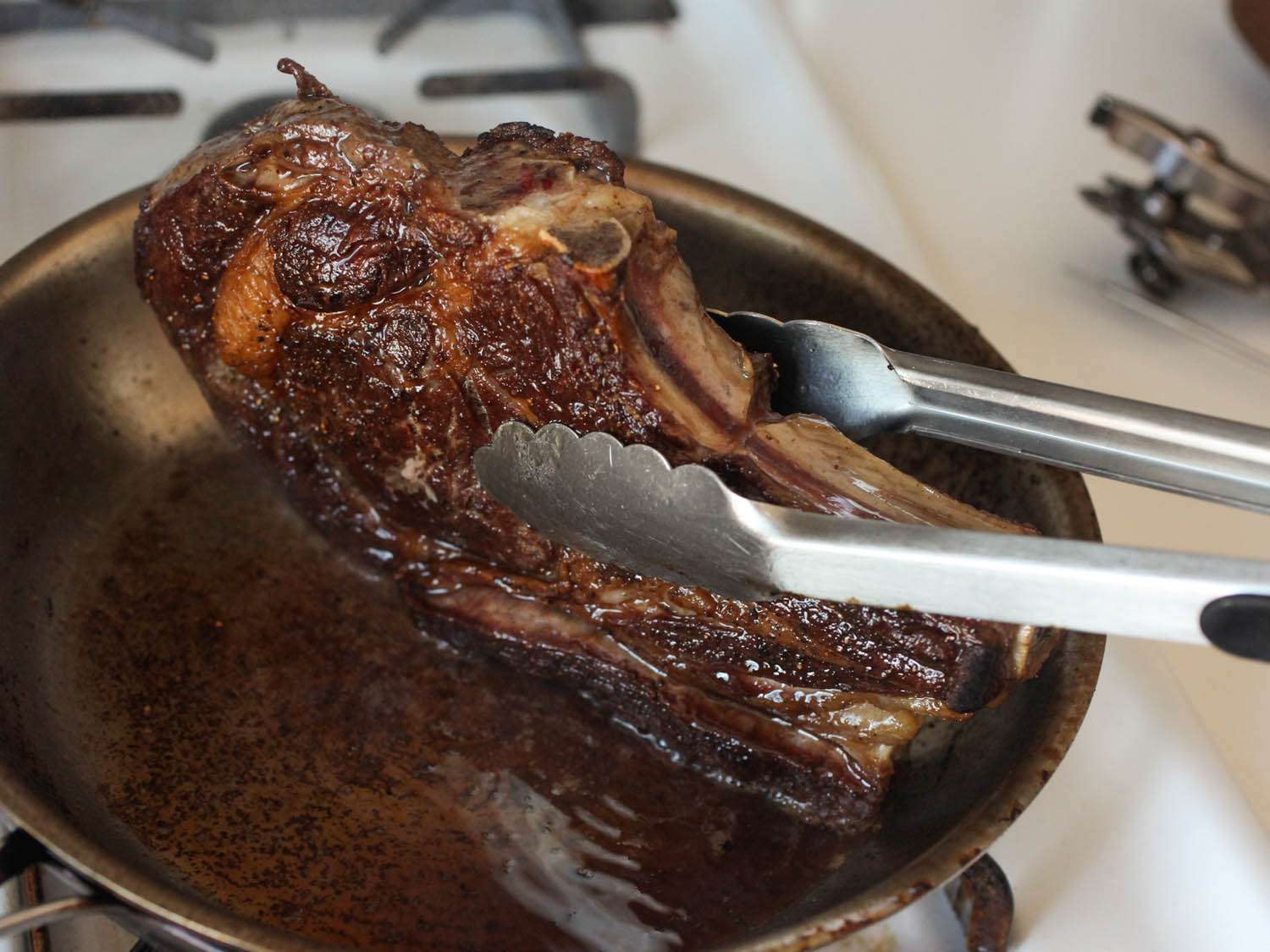Searing the edges of a ribeye steak.