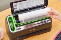 A person installing plastic bag cartilage into a FoodSaver V4400 2-in-1 Vacuum Sealer Machine