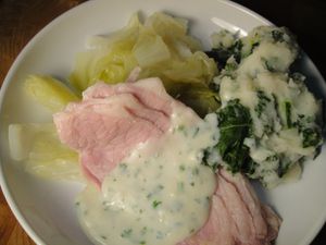 A plate of Irish bacon and cabbage with sauce. 