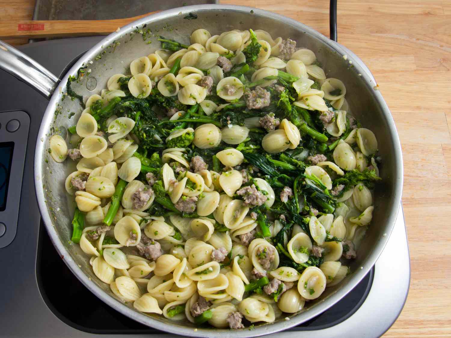 Orecchiette, sausage, and broccoli rabe tossed together in a skillet.