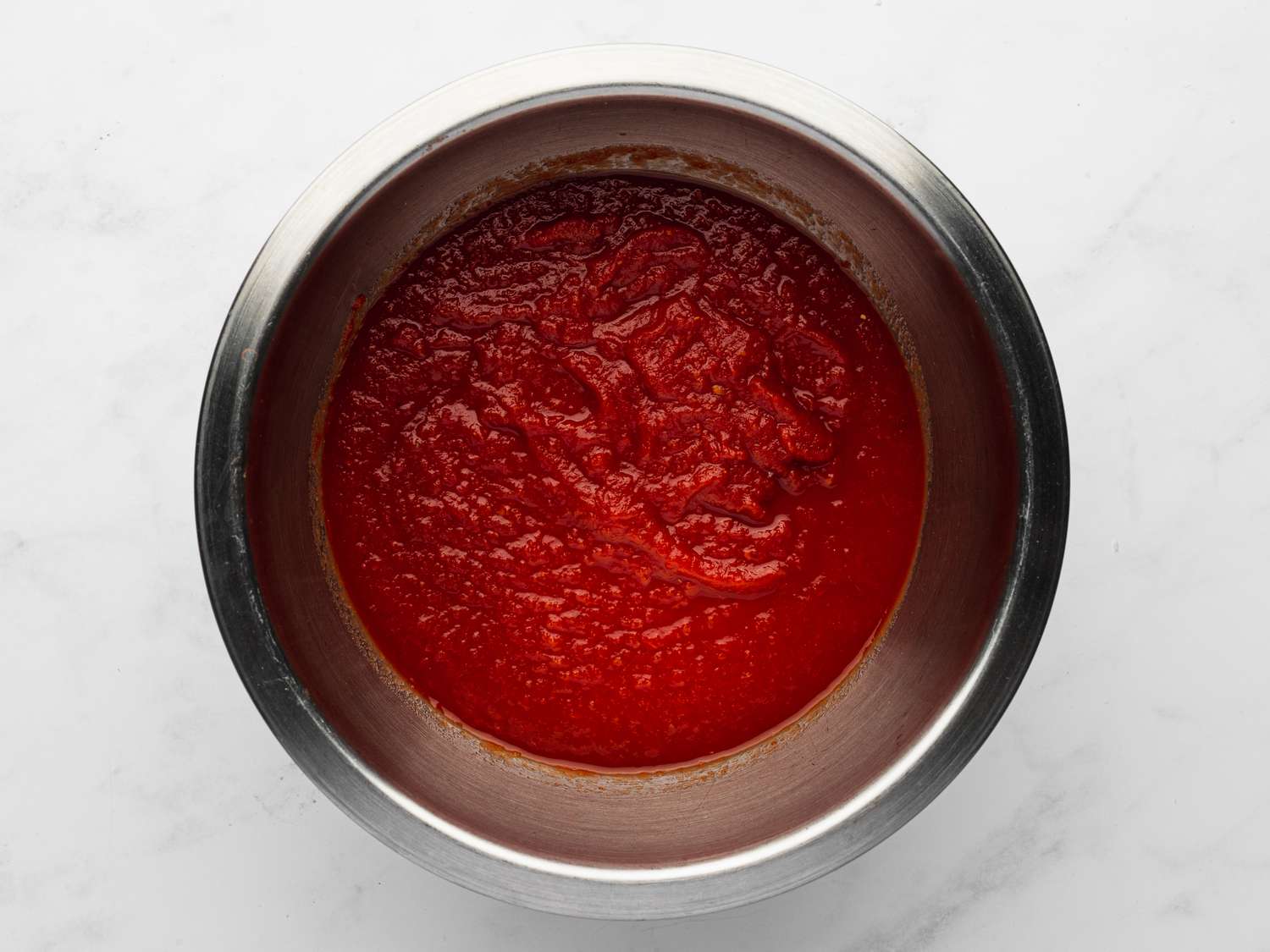  Crushed tomatoes seasoned with salt in a bowl