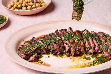 Sliced steak topped with green chermoula served with chickpea salad on the side