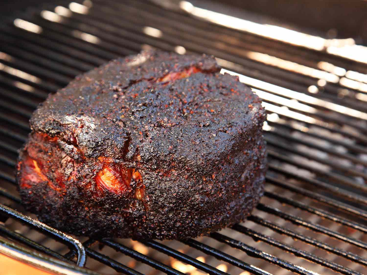 Barbecue chuck roast on the smoker, encased in bark.