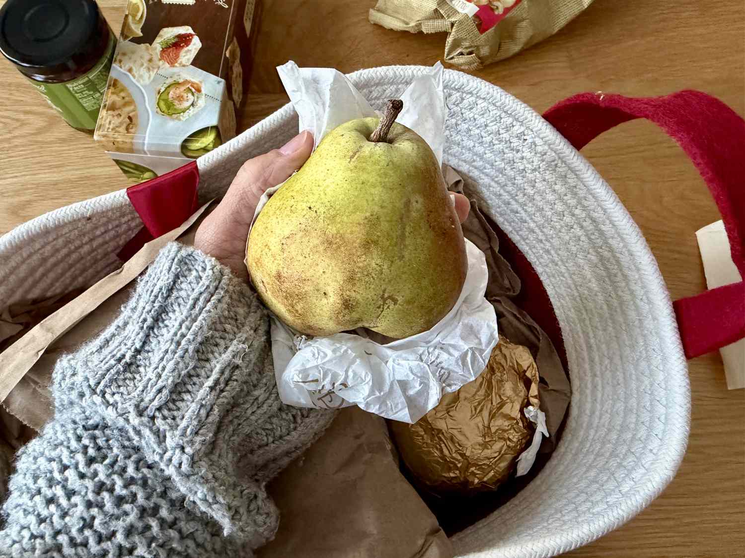 A person holding a pear from the Harry & David gift basket
