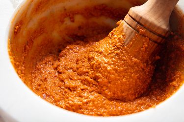 A pestle pounding ingredients for romesco sauce. 