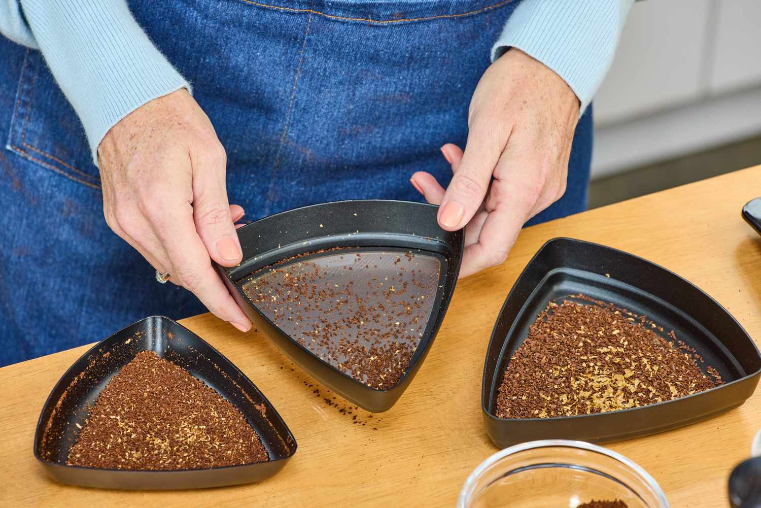 A person examines coffee ground in the Comandante C40 Nitro Blade Grinder