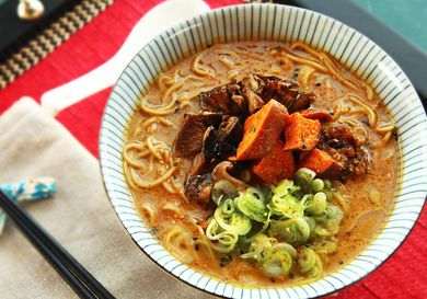 Homemade creamy vegan ramen topped with mushrooms, sweet potatoes, eggplant, and scallions.