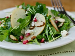 Closeup of Arugula, Apple, and Pomegranate Salad with Cider-Honey Vinaigrette.