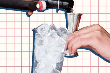 A cup of ice and someone making a cocktail.