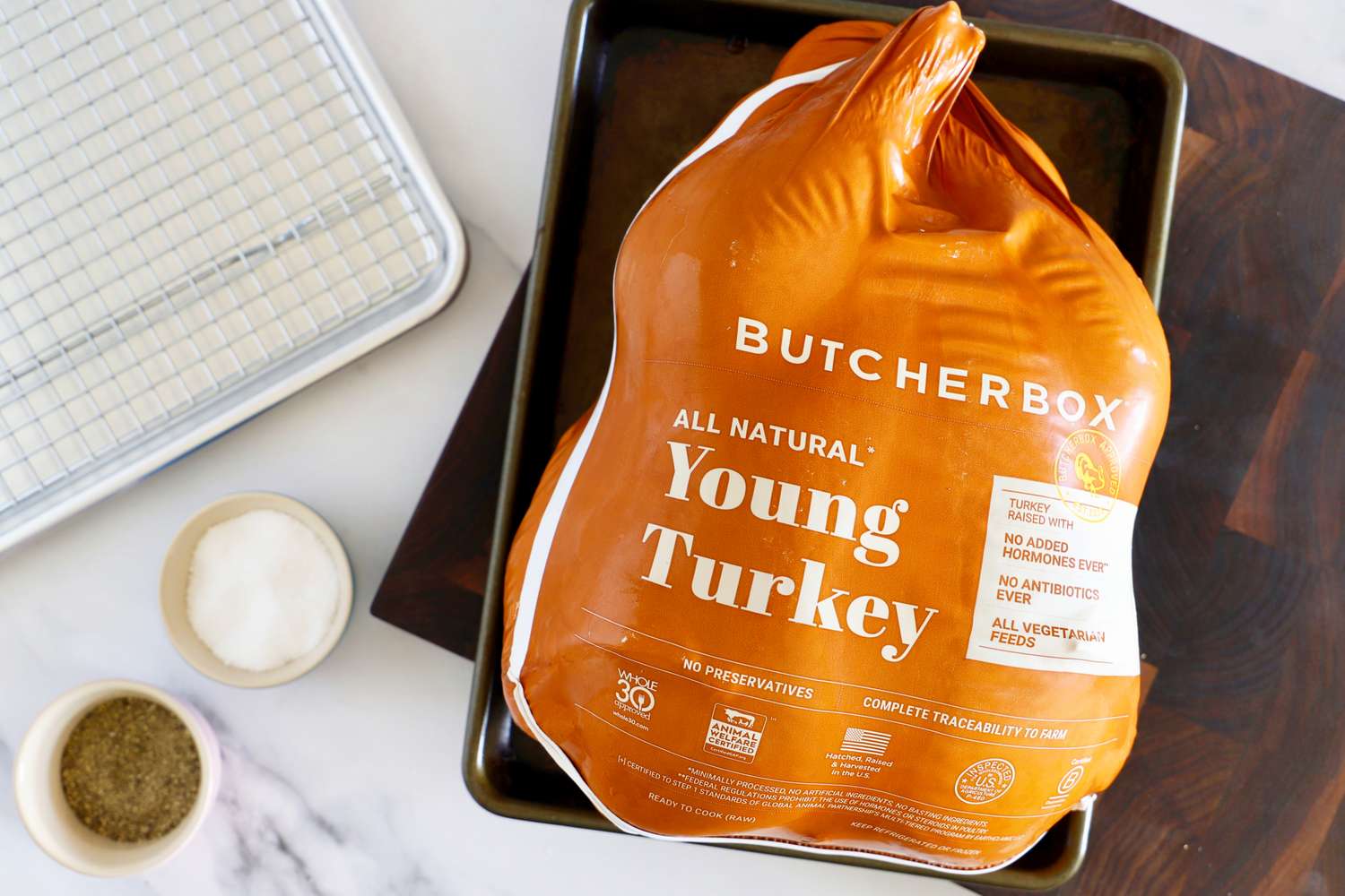 Packaged turkey labeled Young Turkey on a tray with seasoning bowls nearby