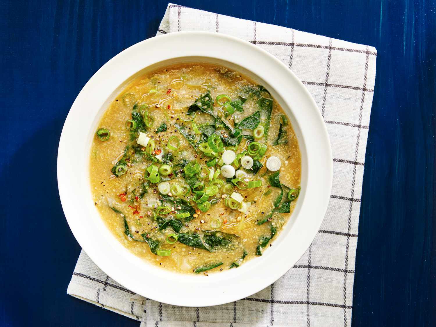 White bowl of Hearty Vegan Polenta and Kale Soup for above
