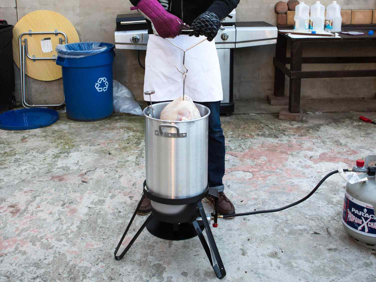 Man lowering turkey into vat of boiling oil