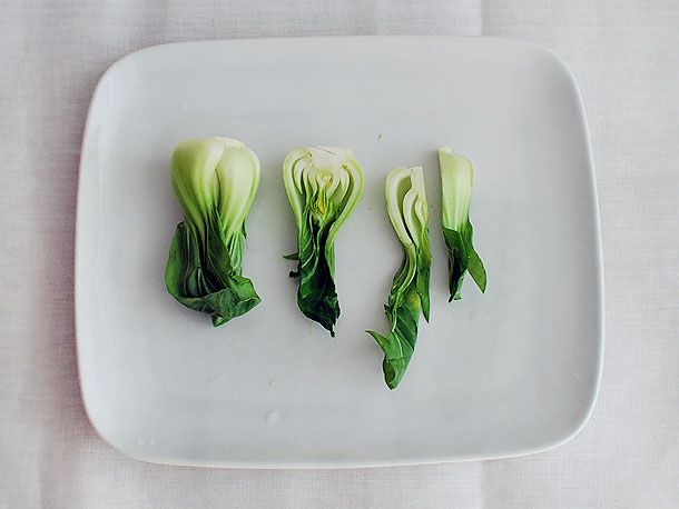 A plate with fresh bok choy, some of it cut in half. 