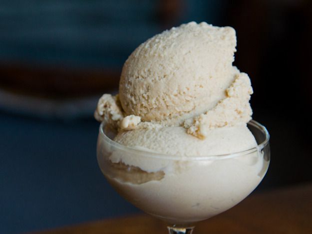 A dish of two scoops of bourbon peach brown sugar ice cream