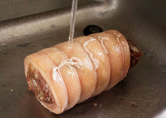 rinsing cooked pork belly under running water
