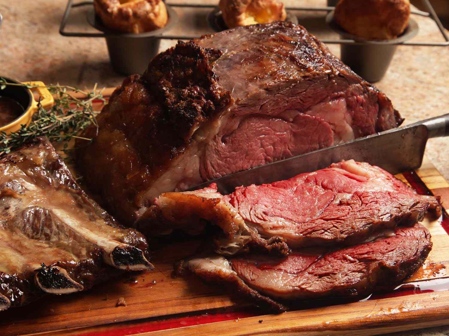 A prime rib roast is carved on a cutting board.