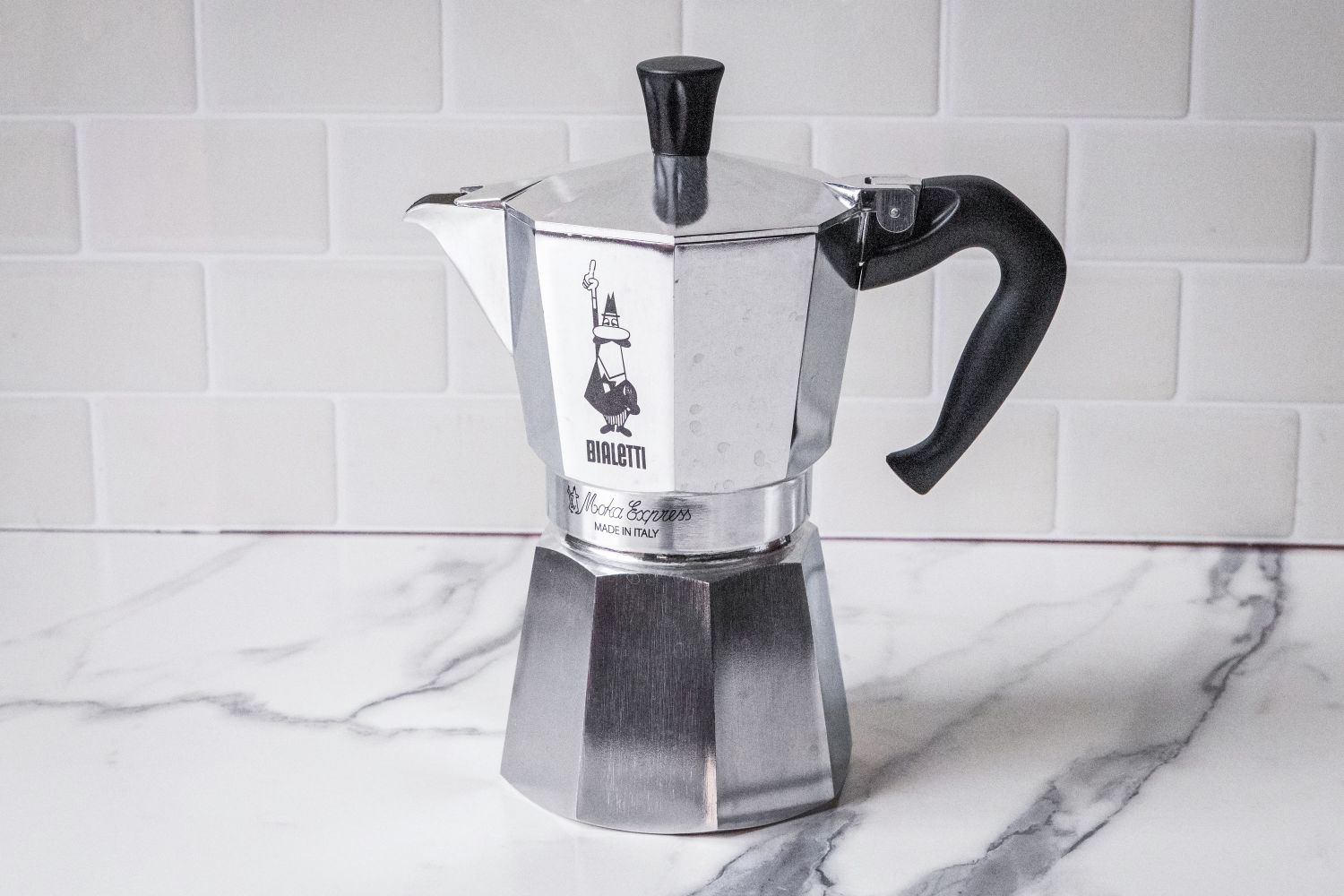 The Bialetti Moka Express moka pot sitting on a marble surface.
