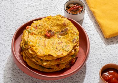 A plate of savory pancakes served with condiments on a table