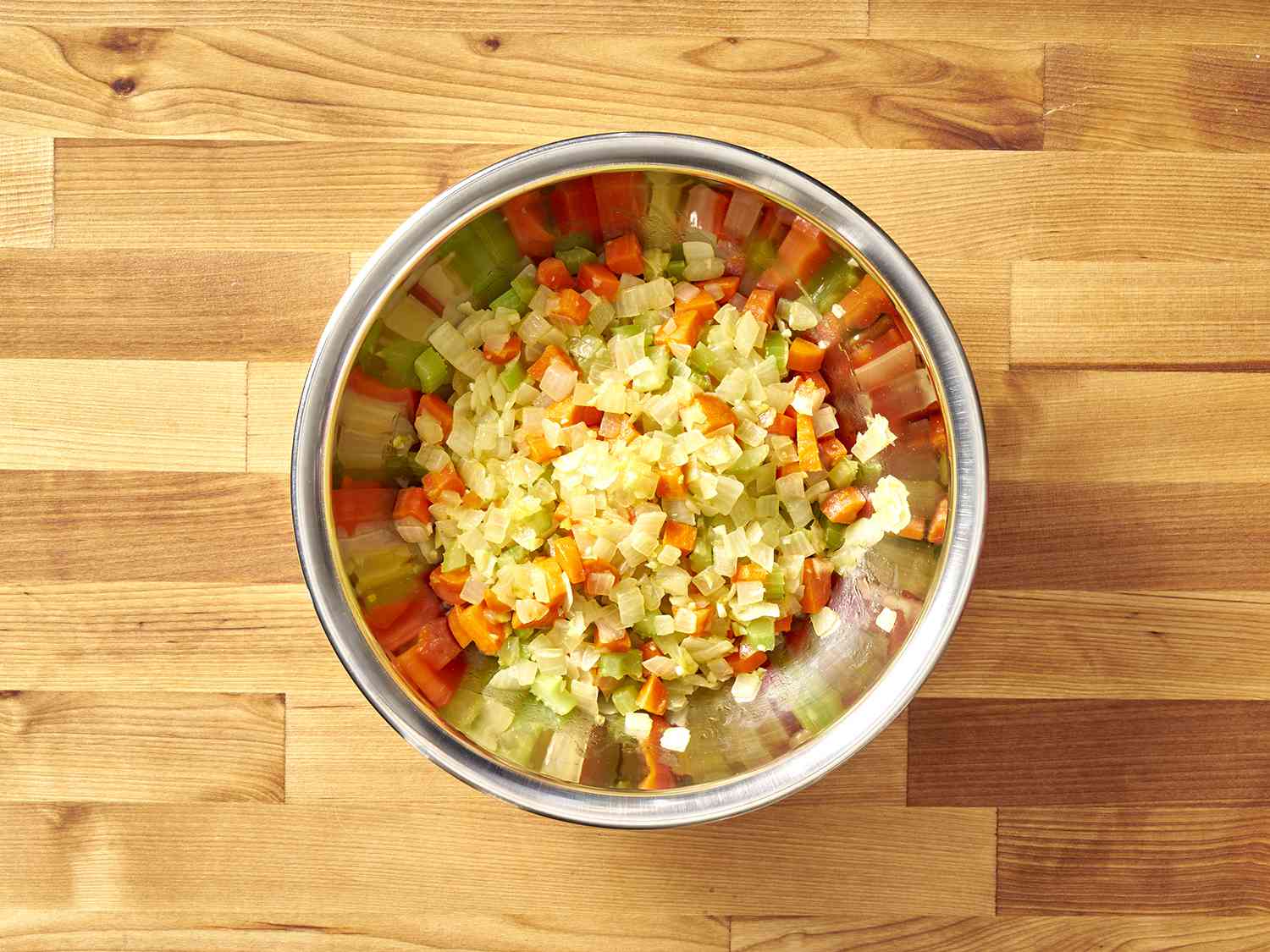 Diced, cooked vegetables in a metal bowl.