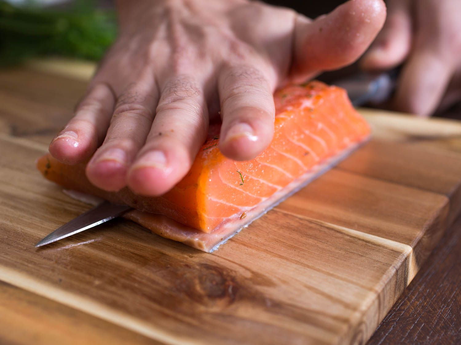Slicing gravlax thinly after cutting fillet in half.