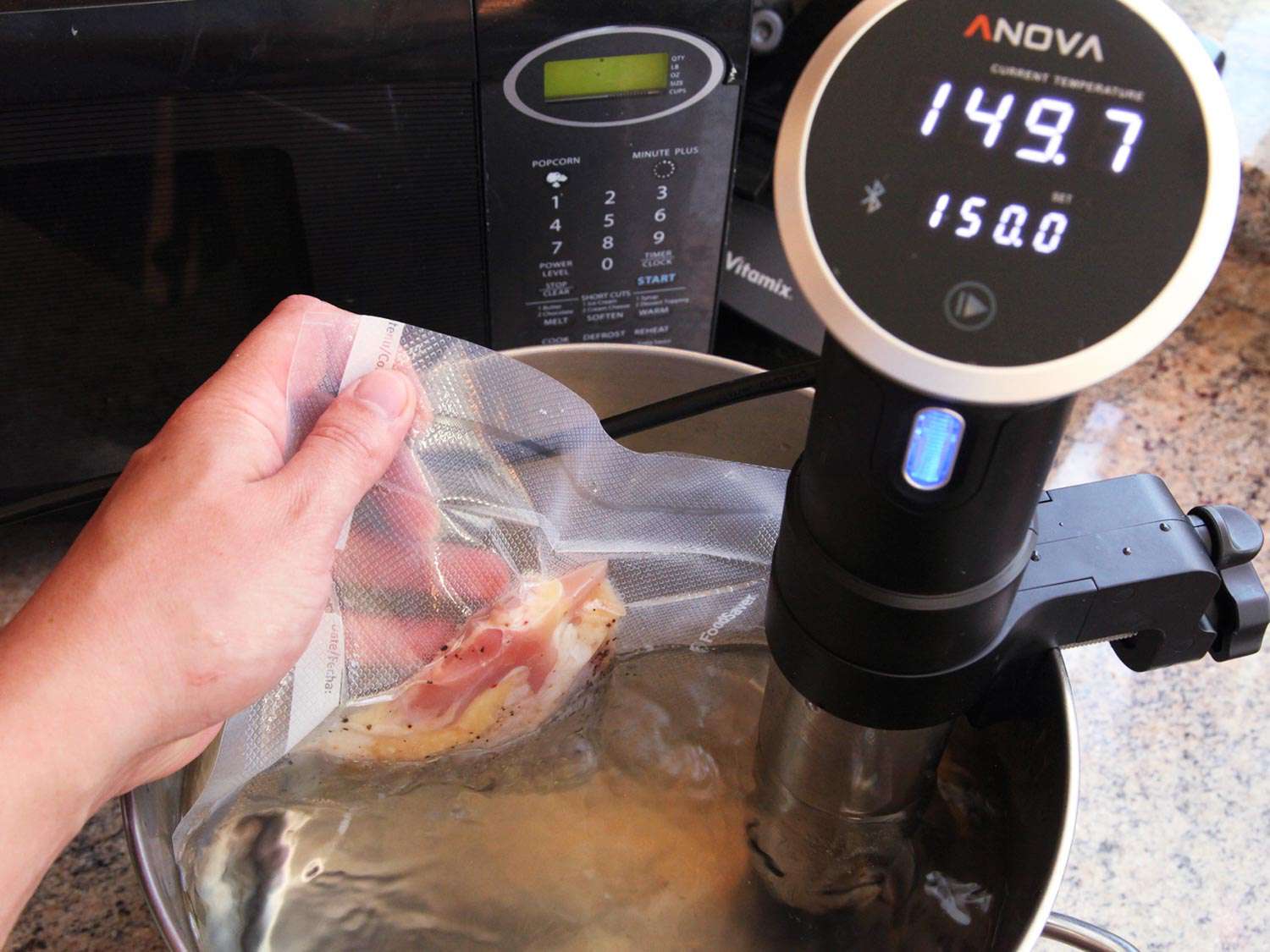 Placing bagged, chicken thighs into a pot with a sous vide circulator.