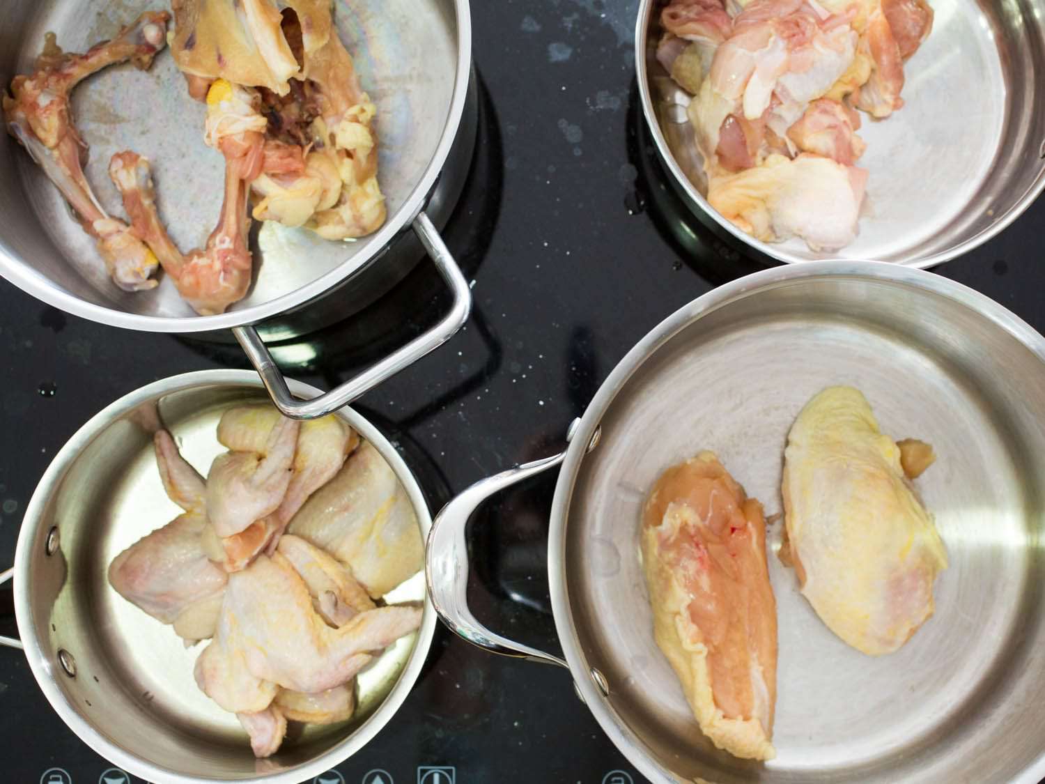Four pots containing different chicken parts.