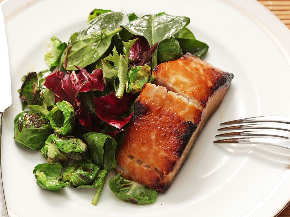 Broiled miso marinated black cod on a serving plate with salad. 