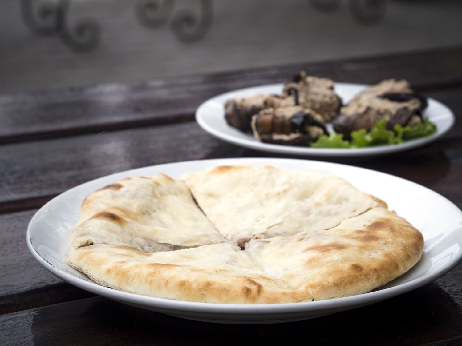 A white plate of Lobiani that has been cut into four pieces. 