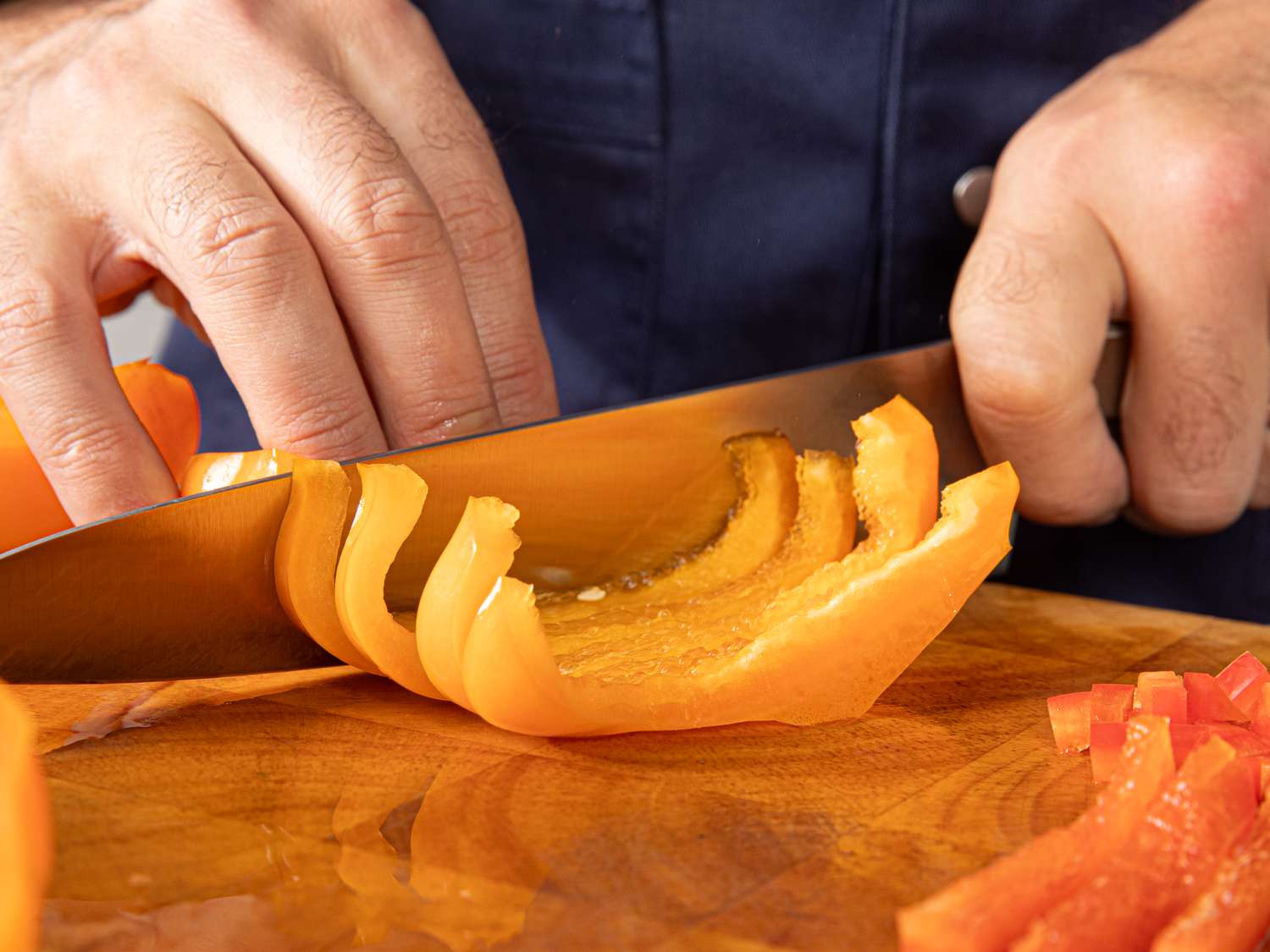 Side view of slicing a bell pepper in strips