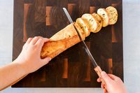 Person slicing bread with Tojiro F-737 Bread Slicer