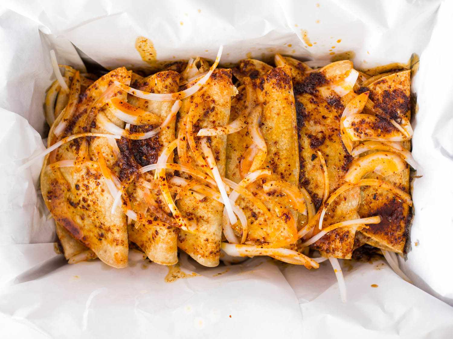Overhead shot of canasta tacos in lined container