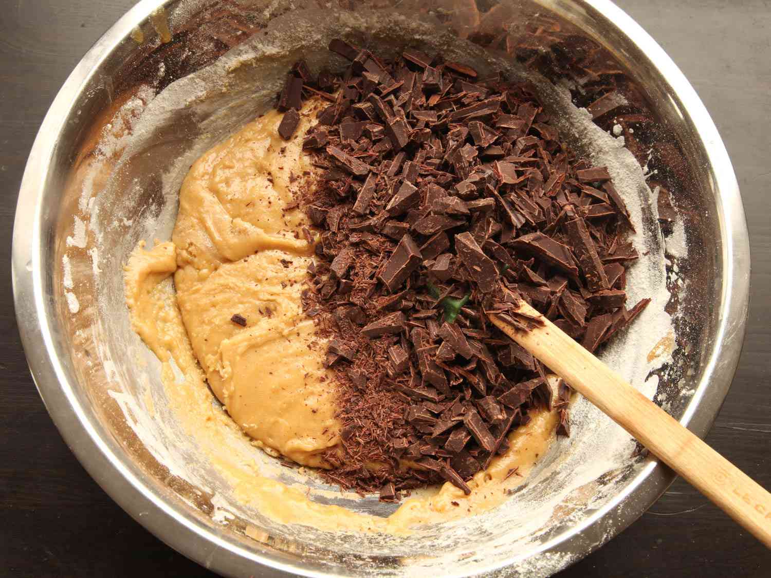 Bowl of cookie dough with topped with mound of chopped chocolate 