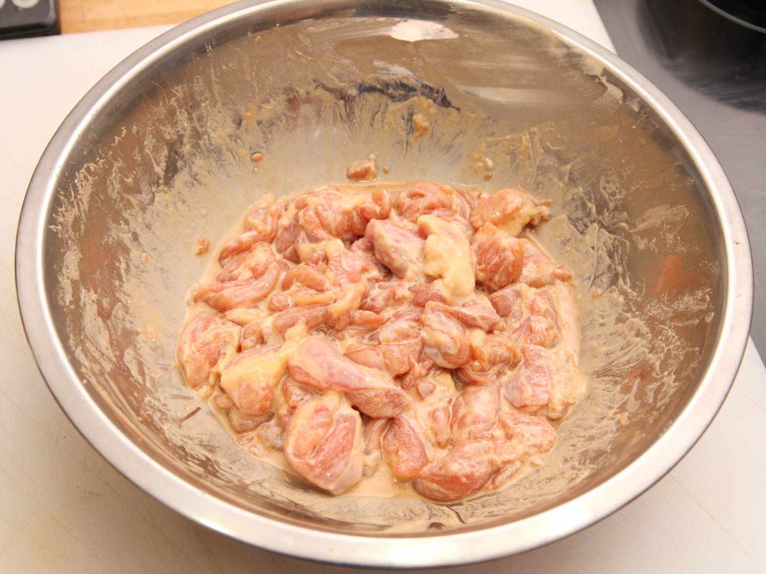 Boneless chicken thighs in a batter-based marinade.