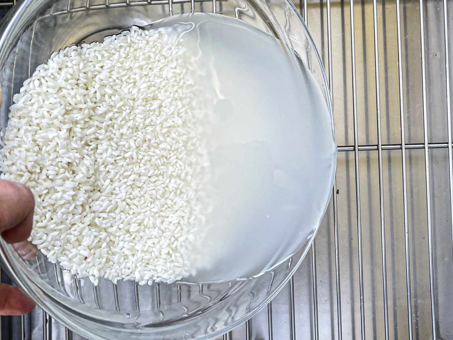 Rice water draining into a kitchen sink.