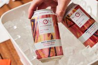 a hand grabbing a can of untitled art's mango dragonfruit fruited sour