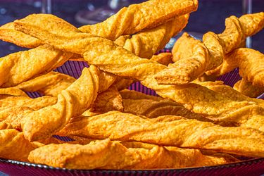 A plate filled with twisted cheese straws displayed on a table