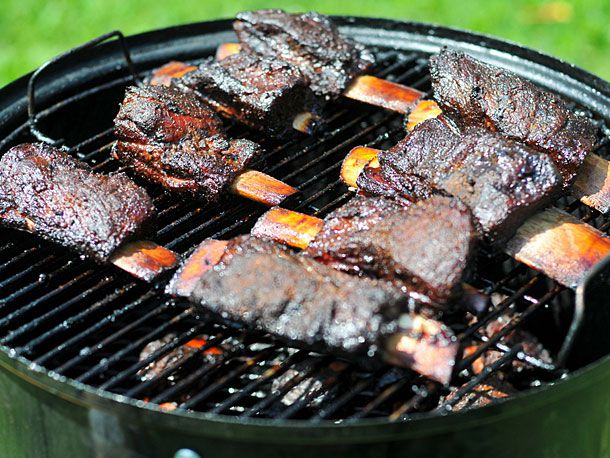 Short ribs lined up and cooking on a smoker